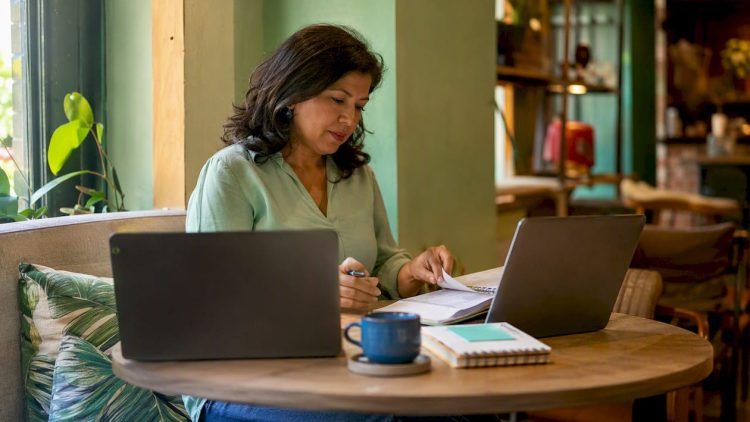 Woman comparing WordPress and Wix on laptops at home office