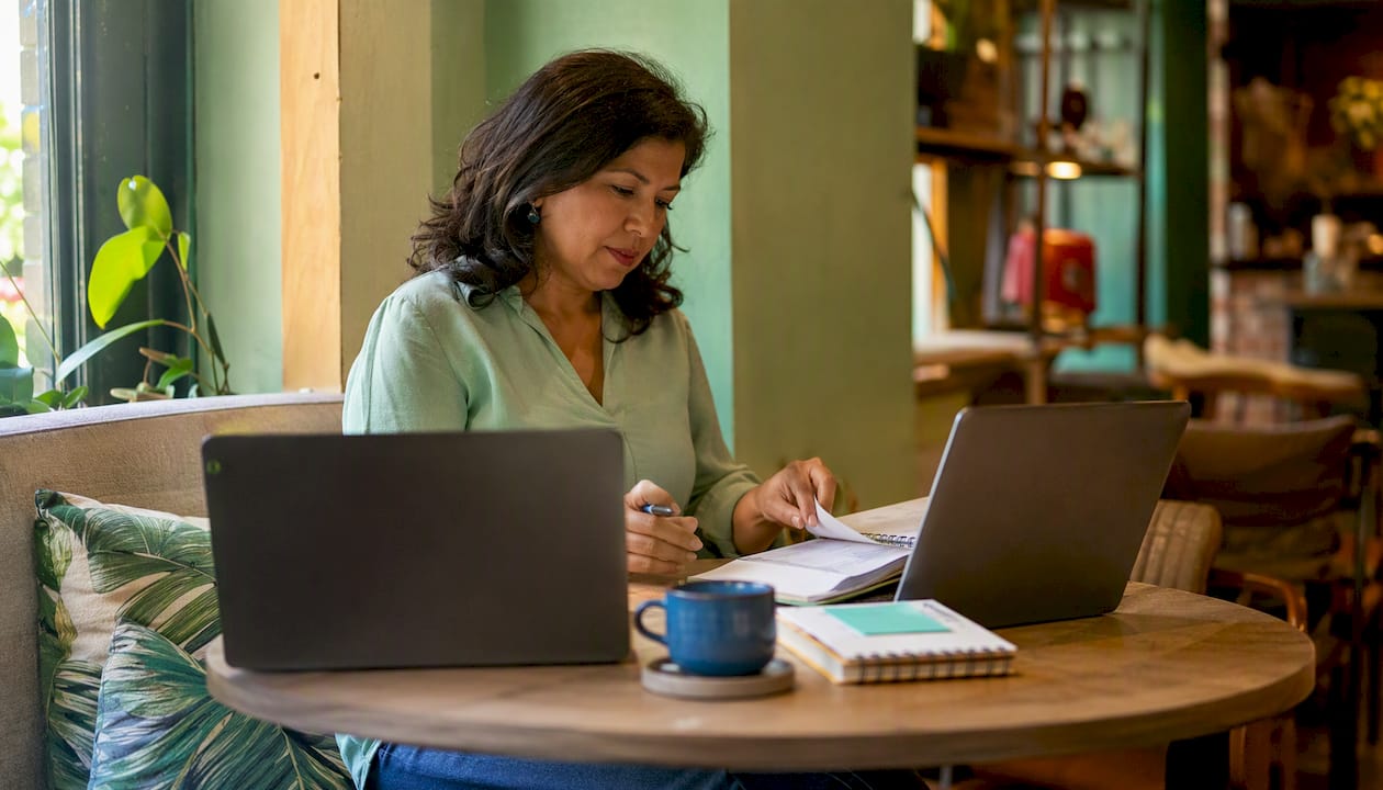 Woman comparing WordPress and Wix on laptops at home office