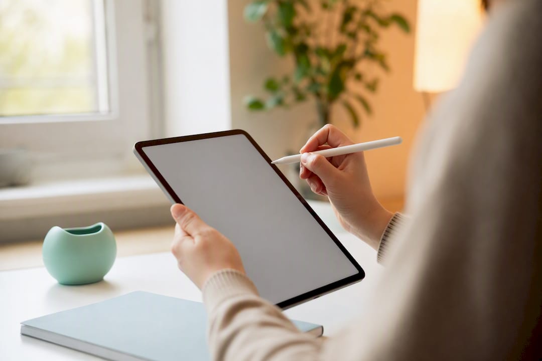 Hands with stylus near tablet representing image alt text