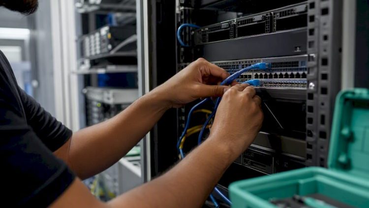 Hands connecting cable to server in data center
