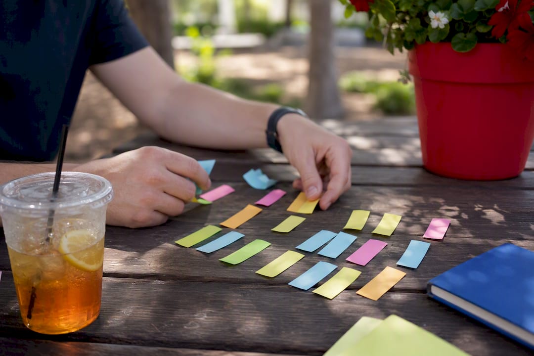 Hand sorting keyword notes on cafe table